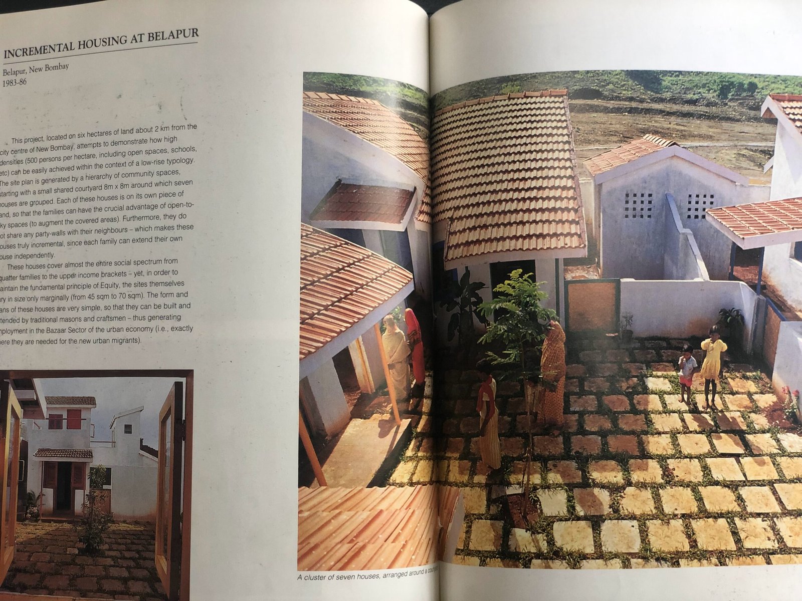 Book spread showing Charles Correa's Incremental Housing at Belapur, a cluster of houses around a shared courtyard